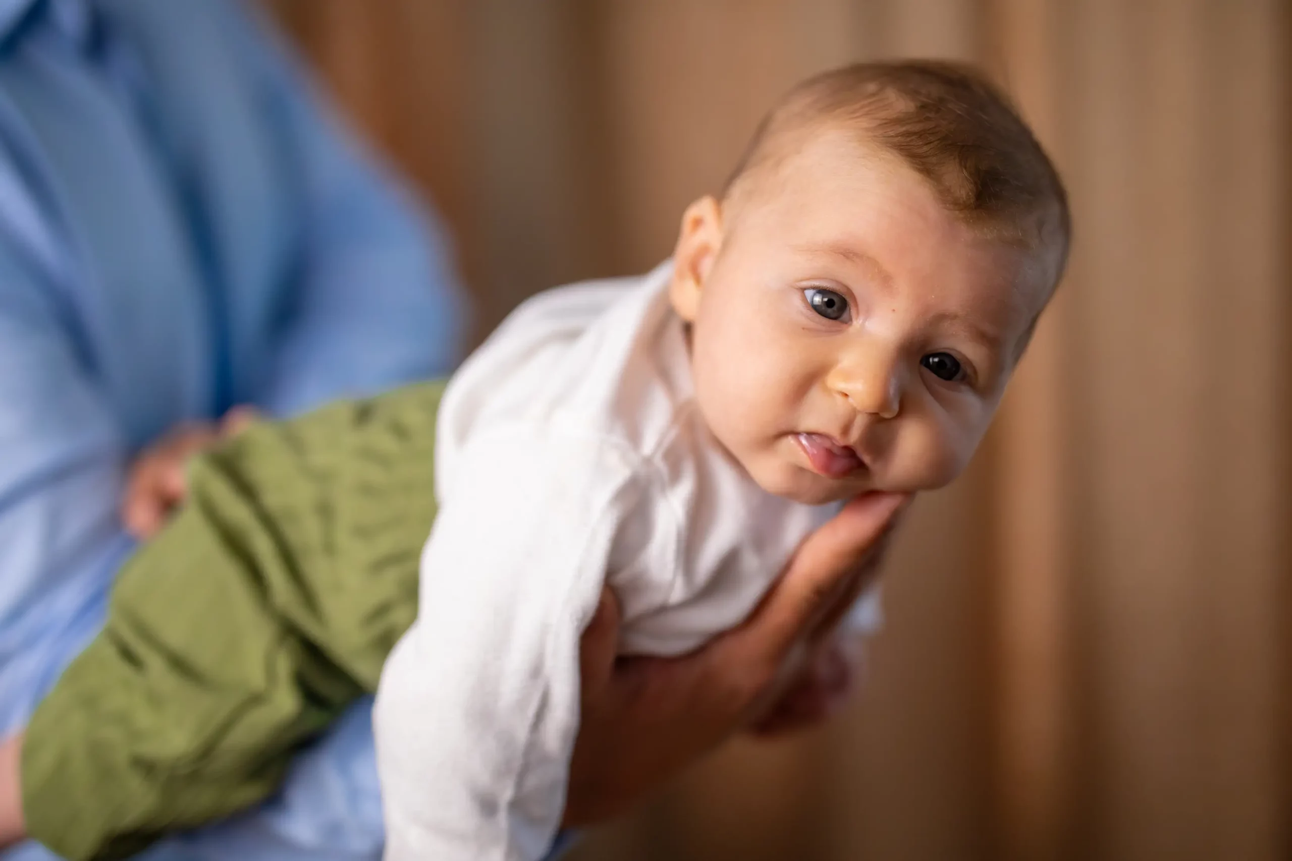 Suesses Baby auf dem Arm von seinem Papa